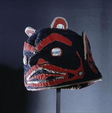 An unusual hat/headdress made from European felt with a bold appliqued design of a face