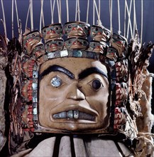 Chiefs headdress with humanoid face surrounded by a row of abalone shell and a double row of smaller faces