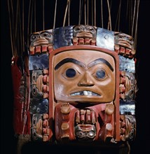 Frontlet with a human figure surrounded by seven smaller figures interspersed with abalone shell