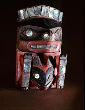 Frontlet plaque carved and painted to represent a beaver with a frog between his front paws