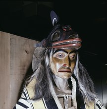Carved and painted figure of a shaman wearing ritual robes and a headdress