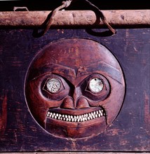 A detail of the moon face carved on a shamans storage chest
