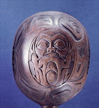 An unpainted shamans rattle carved in low relief