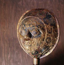 Shamans rattle in the form of a face with a border carved in low relief