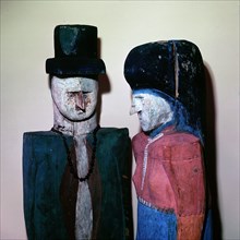 Painted wood carvings of a man and woman in European dress