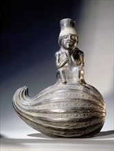 Typically Chimu style blackware ceramic effigy showing man sitting on a gourd