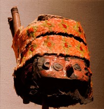 This elaborate death mask, originally attached to a Chimu mummy bundle, has a copper face mask painted red