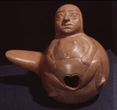 Hollow gourd shaped ceramic vessel which shows a female figure with distended vulva