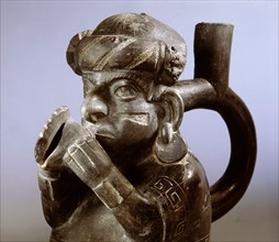 Mochica blackware effigy jar with distinctive north coast type stirrup spout portraying a musician playing a conch shell trumpet