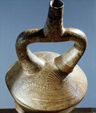 Late Mochica stirrup spouted jar showing an intricately painted supernatural figure with an elaborate feathered headdress and a serpentine body