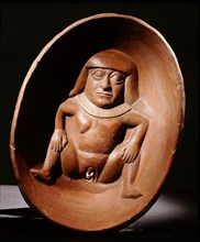 Shallow bowl with relief modelled woman at base with prominent vulva