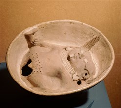 Shallow bowl with relief modelled woman at base with prominent vulva