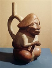 Stirrup spouted vessel depicting seated figure with phallic headdress
