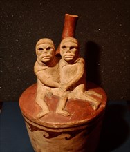 Stirrup spouted vessel depicting an embracing couple with skull like faces