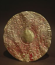 Embossed gold disc, possibly earring or pendant to be suspended from a garment or headdress