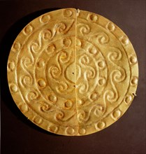 A pair of perforated embossed gold half discs, possibly earrings or pendants to be suspended from a garment or headdress