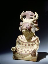 Deer headed anthropomorphic figure with elaborate headdress incorporating an inverted tumi knife