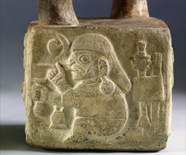 Square, stirrup spouted vessel on one side of which is carved a warrior figure