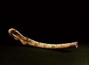 A flute with a bird shaped head and incised with a decorative motif