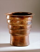 A vessel, possibly a drinking cup, painted with a red glaze