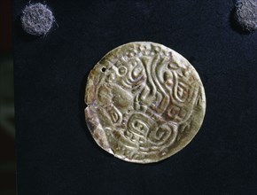 Gold disc embossed with feline images, probably made as an applique piece for a costume