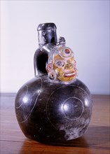 Blackware stirrup spout vessel with trophy head modelled below spout