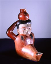 Polychrome jug in the form of a seated figure carrying a pot