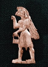 An Assyrian style ivory inlay in Fort Shalmaneser depicting a winged, eagle   headed genie holding a situla and cone