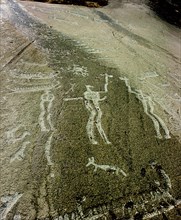 Petroglyph with two men facing each other and brandishing axes