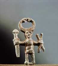 Pendant or amulet of a man holding asword and two spears and wearing ahorned helmet