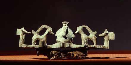 A brooch with two goats on either side of a Thunderstone representing Thor