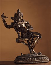 Vajravarahi dancing naked on her toes holding a kartrika knife in her right hand and a skull cup in her left