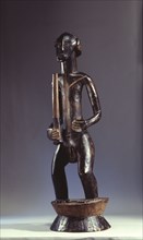 A male figure holding a club, on a flanged cylindrical base