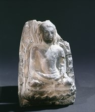 A fragment of a Buddha seated on a lotus blossom