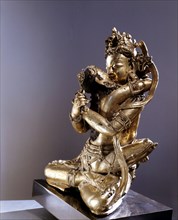 Vajrasattva, also known as Vajradhara, the Supreme Buddha, identified by his hands which are held in the Vajrahumkara mudra, a thunderbolt in each, sits in yab yum with the Supreme Wisdom Visvatara