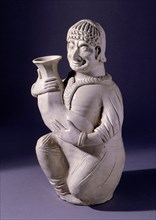 Figure of a Western Asian man holding a wine flask