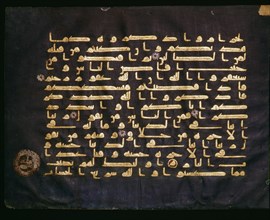 A leaf from a Koran with gold Kufic script on blue parchment