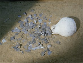 A hoard of old coins found buried in a ceramic jar