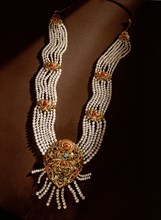 A multi strand pearl necklace with elaborate fittings of gold and semi precious stones