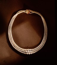 A three strand pearl necklace with gold clasp