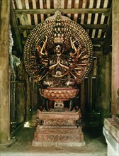 A statue of the Buddha of a Thousand Arms and Thousand Eyes, seated on a lotus