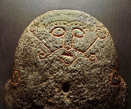 Detail of a forge stone incised with the face of the god Loki with lips sewn together