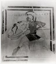 A terracotta slab painted with a running hoplite carrying a spear and shield