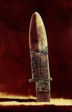 Ko axe with bronze handle and jade blade, incised with designs including an animal mask
