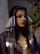 A woman wearing an elaborate silver headdress and traditional costume