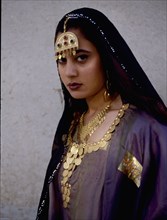 A woman wearing impressive gold jewellery and traditional costume