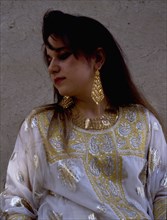 A woman wearing impressive gold jewellery and traditional costume