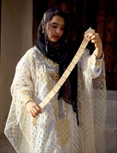 Young woman holding an elaborate gold belt