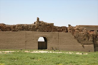 View of the remains of the mud-brick wall enclosing the Temple of Hathor complex and in front a reconstructed section of the wall with an entrance