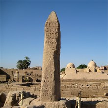 View of the ancient dock area of the Precinct of Amun with stela in the foreground and medieval Islamic buildings in the background